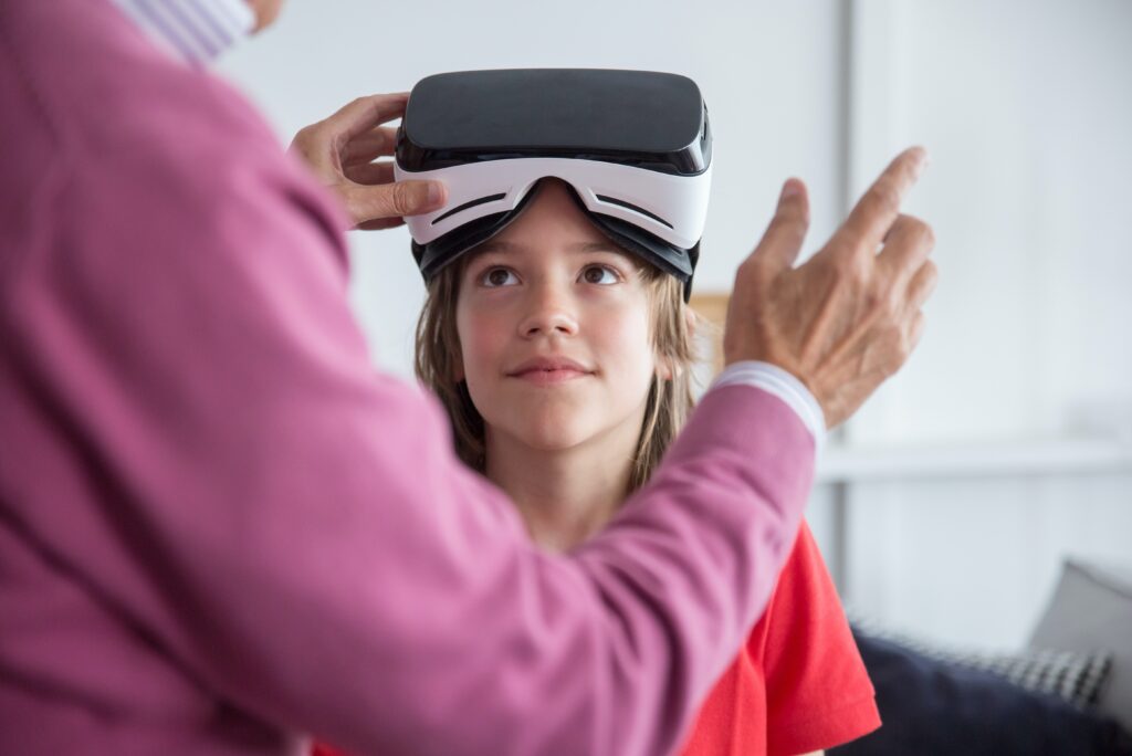 Los Niños Interactúan Usando Auriculares De Realidad Virtual Para  Interactuar Con El Mundo Imaginario. Niño Caucásico Sentado En La Cama En  Casa Usando Gafas Vr Jugando Videojuegos. Aprendizaje Inmersivo Y Niños  Fotos